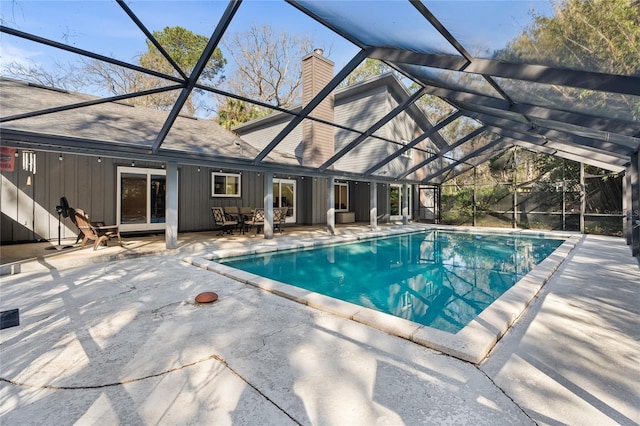 pool featuring glass enclosure and a patio