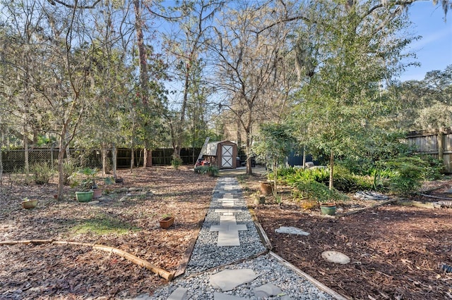 exterior space with a fenced backyard, an outdoor structure, and a storage shed