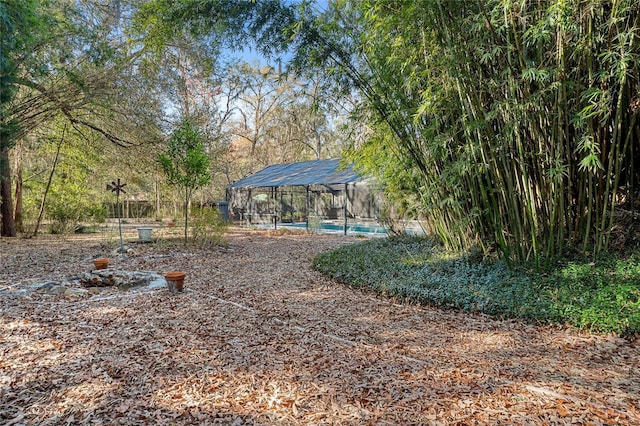 view of yard with glass enclosure and an outdoor pool