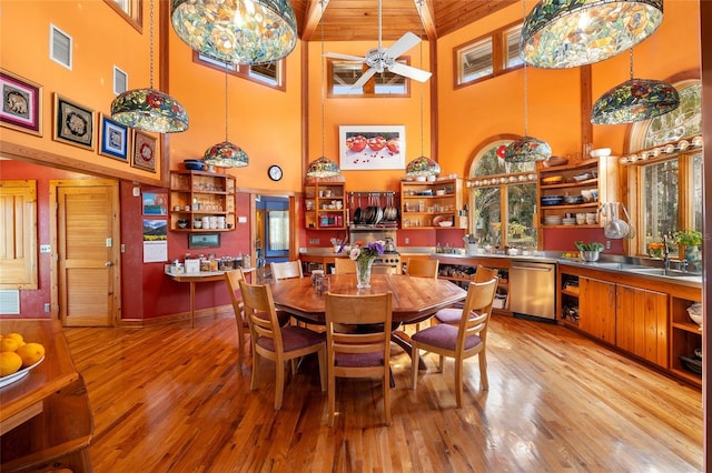 dining area featuring sink, beamed ceiling, light hardwood / wood-style floors, and ceiling fan