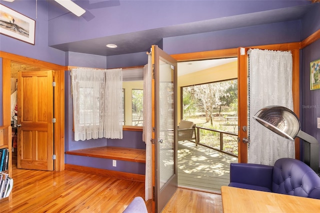 doorway with ceiling fan and light hardwood / wood-style flooring