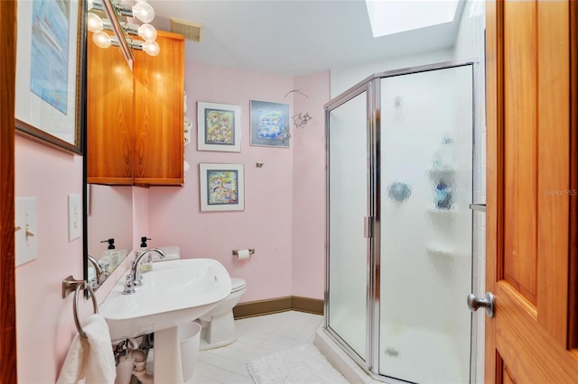 bathroom with toilet, a skylight, and a shower with door