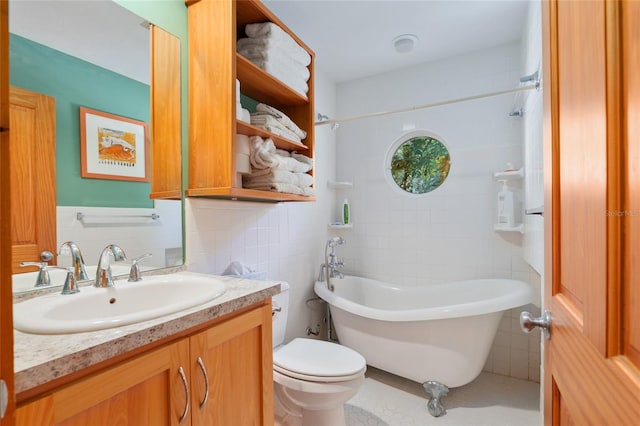 bathroom featuring tile walls, a tub to relax in, vanity, and toilet