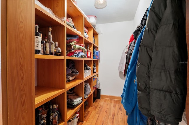 walk in closet with light hardwood / wood-style floors