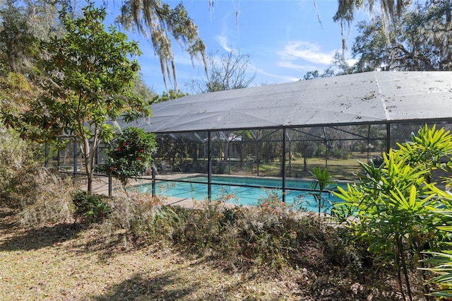 view of pool featuring glass enclosure