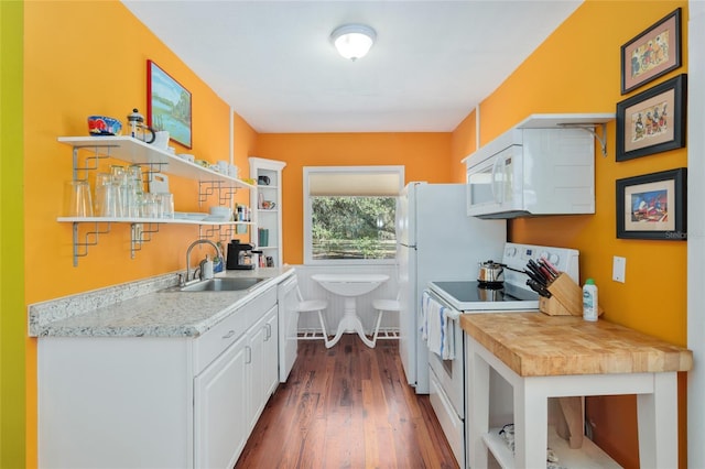 kitchen with white appliances, dark hardwood / wood-style floors, sink, and white cabinets