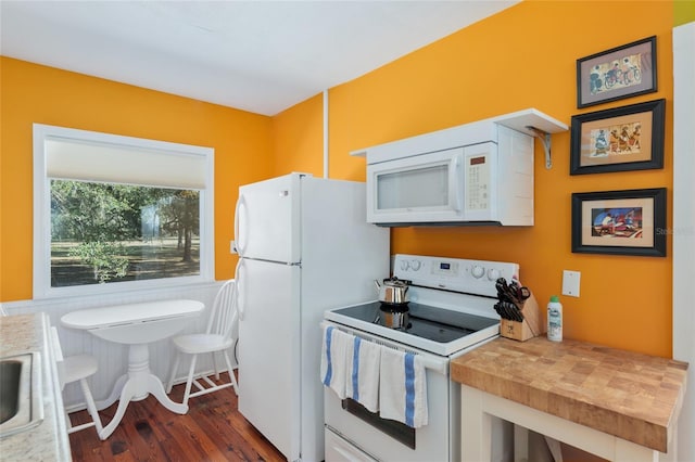 kitchen featuring sink, white appliances, wooden counters, white cabinetry, and dark hardwood / wood-style floors