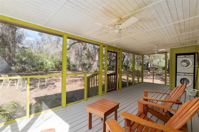 sunroom with wooden ceiling, stacked washer and clothes dryer, and ceiling fan