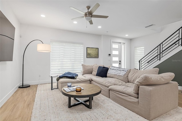 living room with ceiling fan and light wood-type flooring