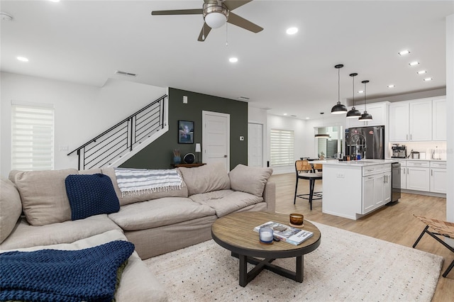 living room with ceiling fan and light hardwood / wood-style floors