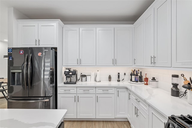 kitchen featuring appliances with stainless steel finishes, light hardwood / wood-style floors, and white cabinets