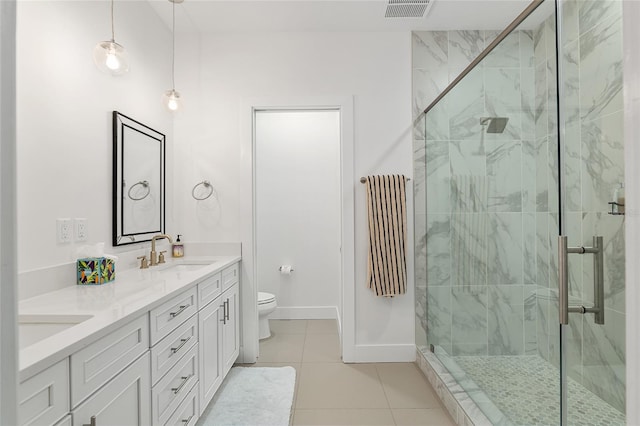 bathroom featuring tile patterned flooring, vanity, a shower with shower door, and toilet