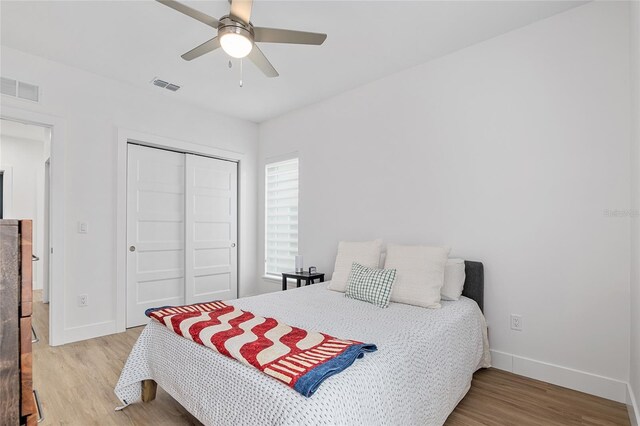 bedroom featuring ceiling fan, a closet, and light wood-type flooring