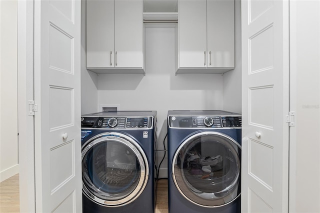 washroom with hardwood / wood-style floors, cabinets, and independent washer and dryer