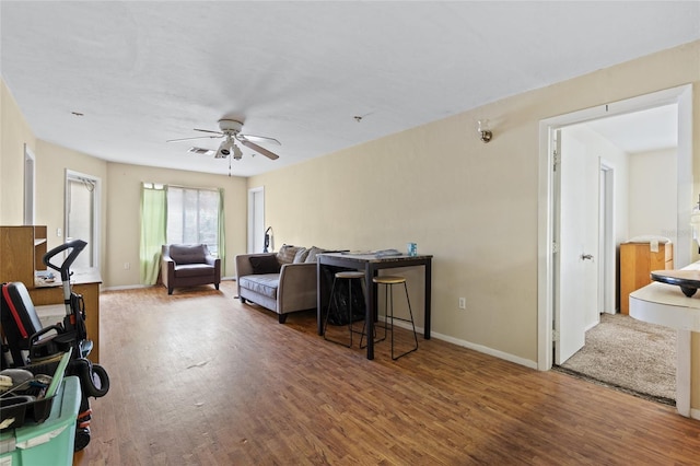 living room featuring dark hardwood / wood-style floors and ceiling fan