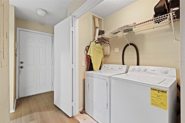 clothes washing area with washer and clothes dryer and light hardwood / wood-style floors