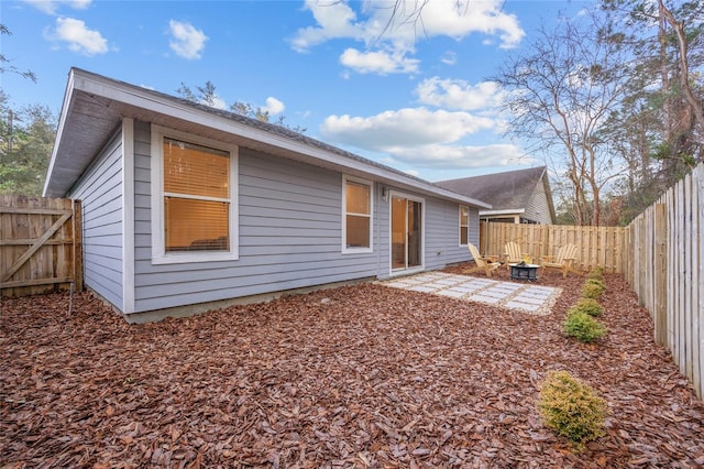 rear view of house featuring a fire pit and a patio