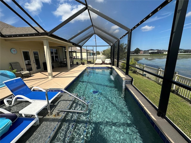 view of swimming pool with pool water feature, french doors, a patio area, a water view, and glass enclosure