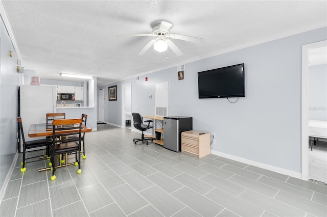 living room with ceiling fan, ornamental molding, and a textured ceiling