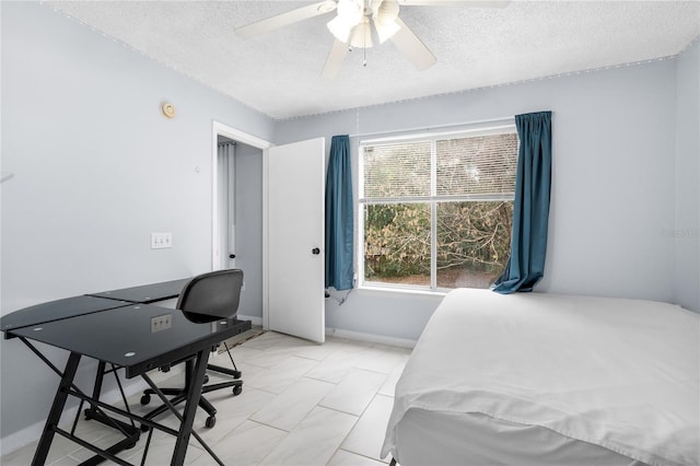 bedroom featuring ceiling fan and a textured ceiling