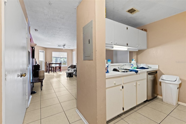 kitchen featuring light tile patterned floors, stainless steel dishwasher, white cabinets, and electric panel