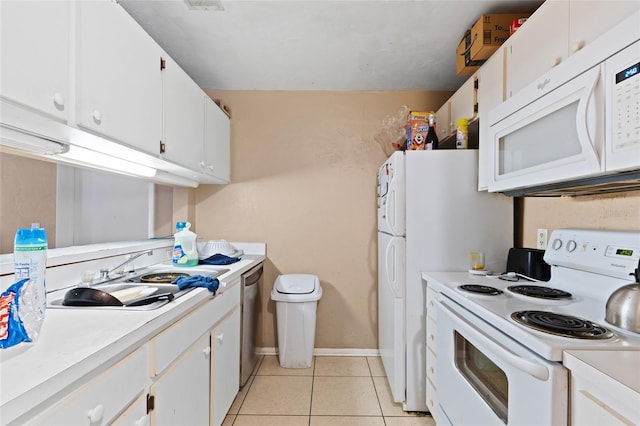 kitchen with sink, light tile patterned floors, white cabinets, and white appliances