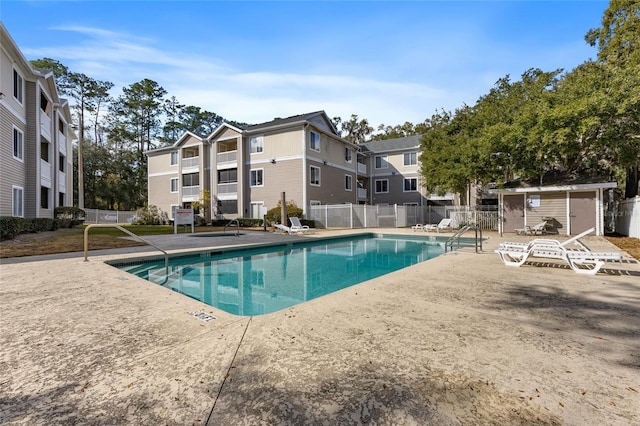 view of pool with a shed and a patio