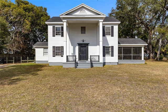 neoclassical / greek revival house featuring a sunroom and a front yard