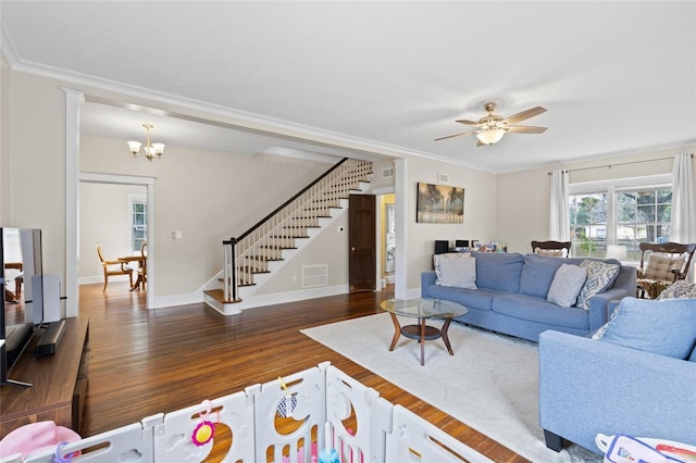 living room featuring dark wood-type flooring, crown molding, and ceiling fan with notable chandelier