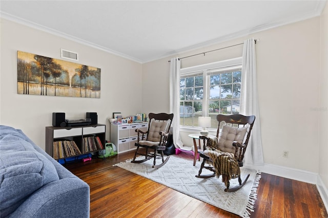 sitting room with crown molding and dark hardwood / wood-style flooring