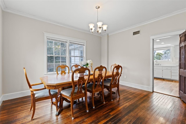 dining area featuring a notable chandelier, dark wood-type flooring, and ornamental molding