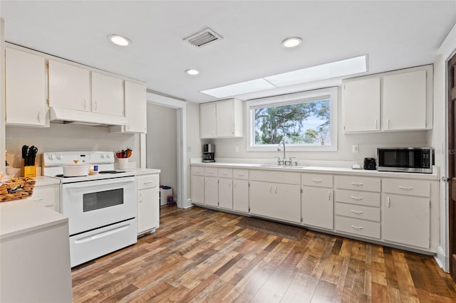 kitchen featuring white electric stove, white cabinetry, hardwood / wood-style flooring, and sink