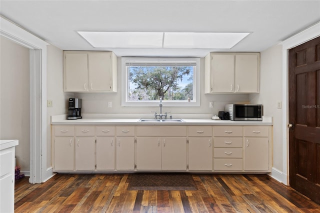 kitchen featuring dark hardwood / wood-style floors, sink, and white cabinets