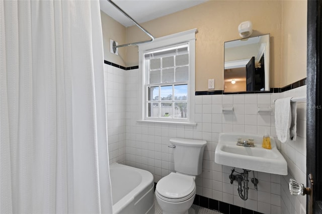 full bathroom featuring  shower combination, toilet, sink, and tile walls