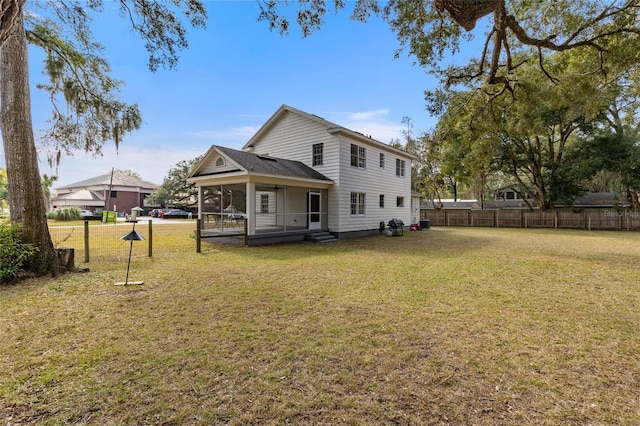 rear view of house with a sunroom and a yard