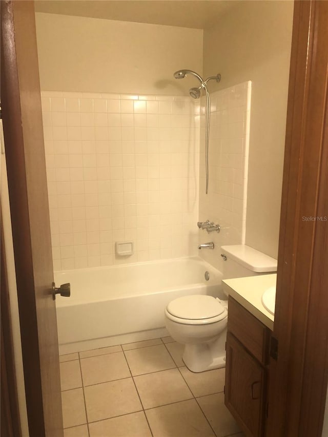 full bathroom featuring tiled shower / bath combo, vanity, tile patterned floors, and toilet