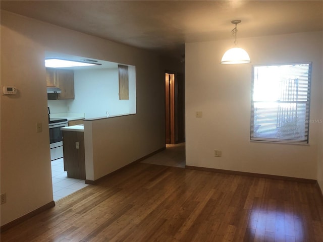 kitchen with decorative light fixtures, light wood-type flooring, and electric stove