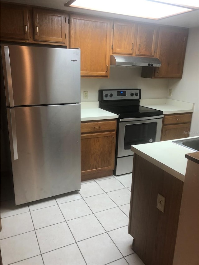 kitchen with light tile patterned floors and stainless steel appliances