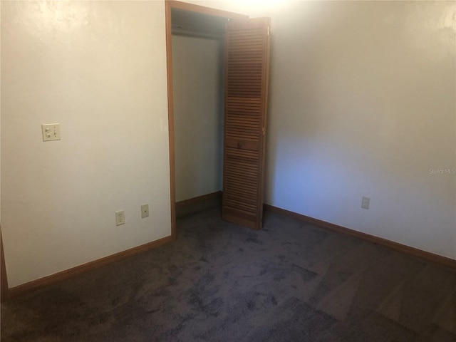 empty room featuring dark colored carpet