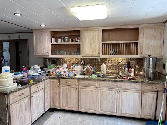 kitchen featuring dark stone countertops, sink, decorative backsplash, and light brown cabinets