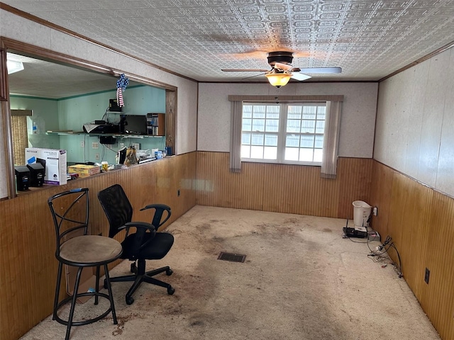 interior space featuring ornamental molding, ceiling fan, and wooden walls