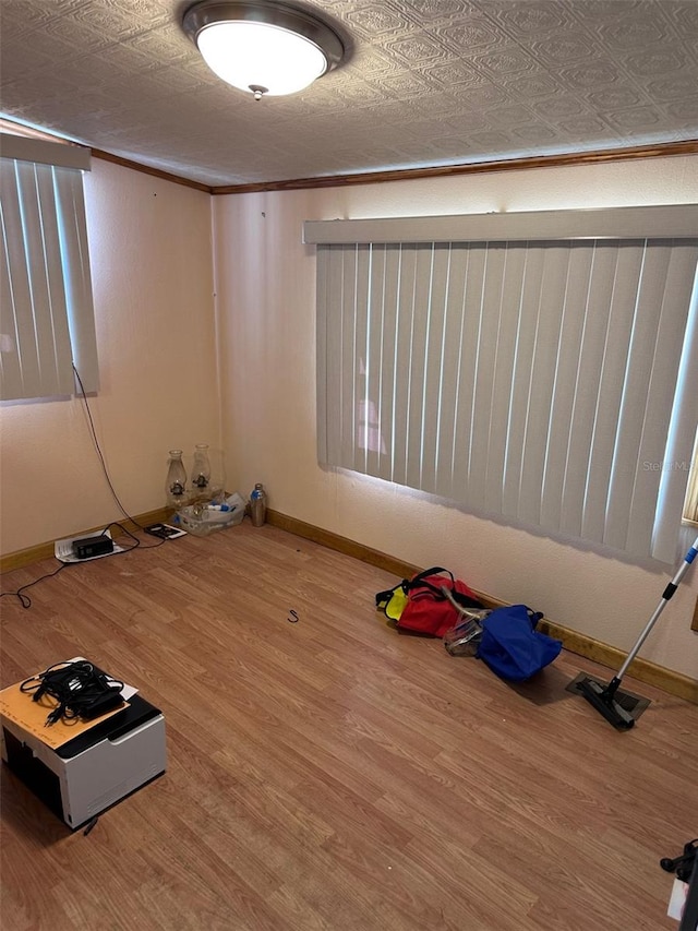 empty room with ornamental molding and hardwood / wood-style floors