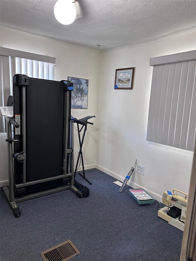 workout area with dark carpet and a textured ceiling