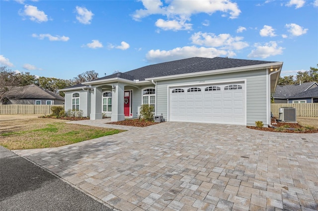 single story home with central AC unit, a garage, and a front yard