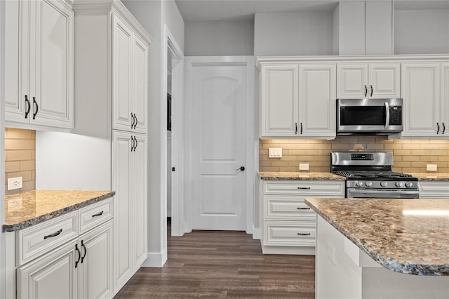 kitchen featuring stainless steel appliances, dark wood-type flooring, and white cabinets