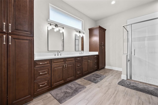 bathroom featuring hardwood / wood-style flooring, vanity, and a shower with shower door