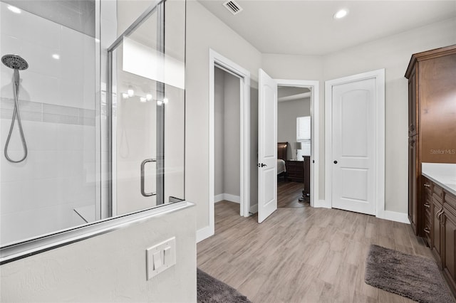 bathroom with an enclosed shower, vanity, and hardwood / wood-style flooring