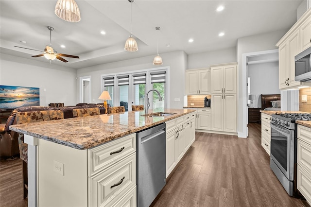 kitchen with sink, stainless steel appliances, a kitchen breakfast bar, and a center island with sink