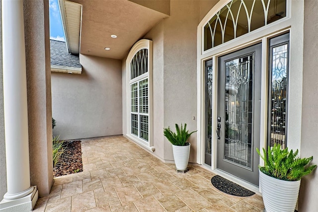 view of exterior entry with a patio