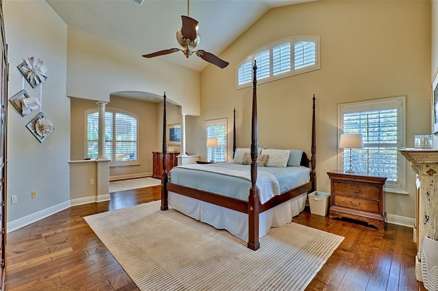 bedroom featuring high vaulted ceiling, hardwood / wood-style flooring, decorative columns, and ceiling fan